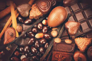 Luxury chocolate close up. Candies Chocolate vintage style. Delicious assortment of white, dark, milk chocolate bonbon with nuts, vanilla and cinnamon. Belgium chocolate
