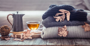 Cozy autumn still life with a cup of tea and decor items in the living room. Home comfort concept